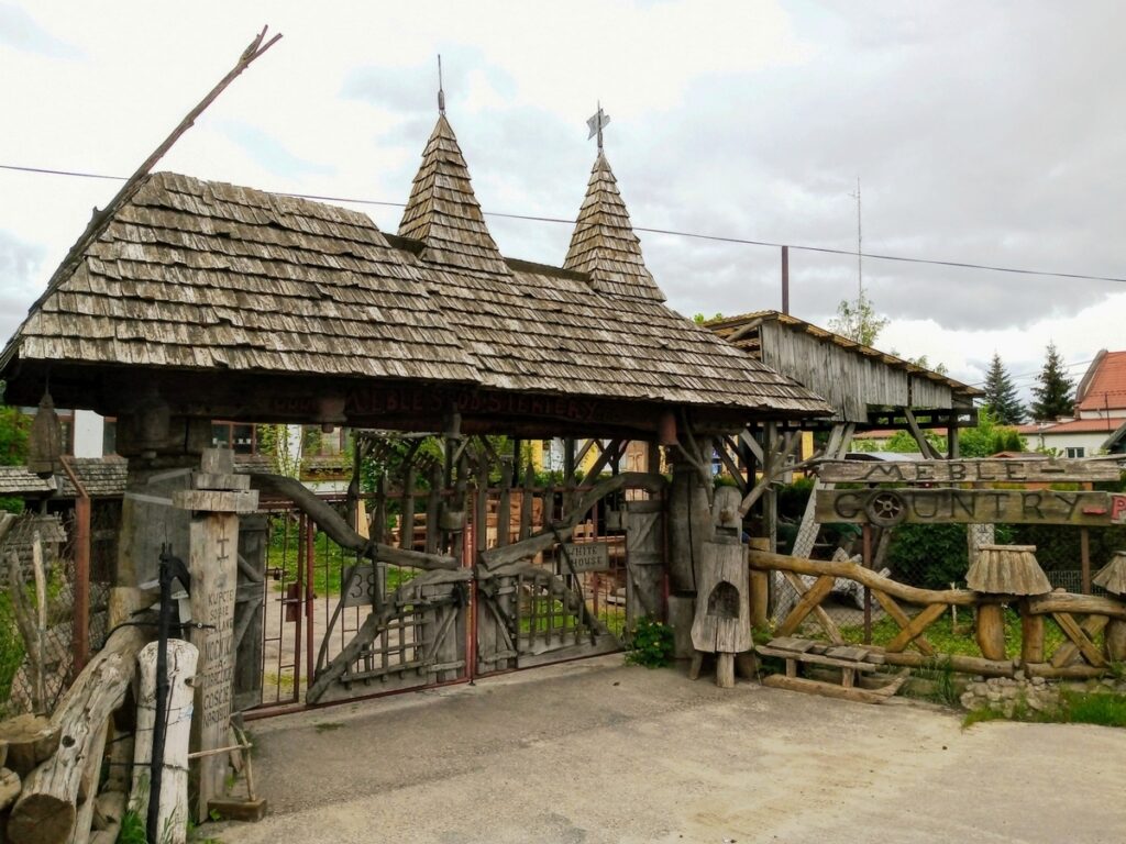 Olsztynek. Drewniana brama koło Huty Szkła Artystycznego