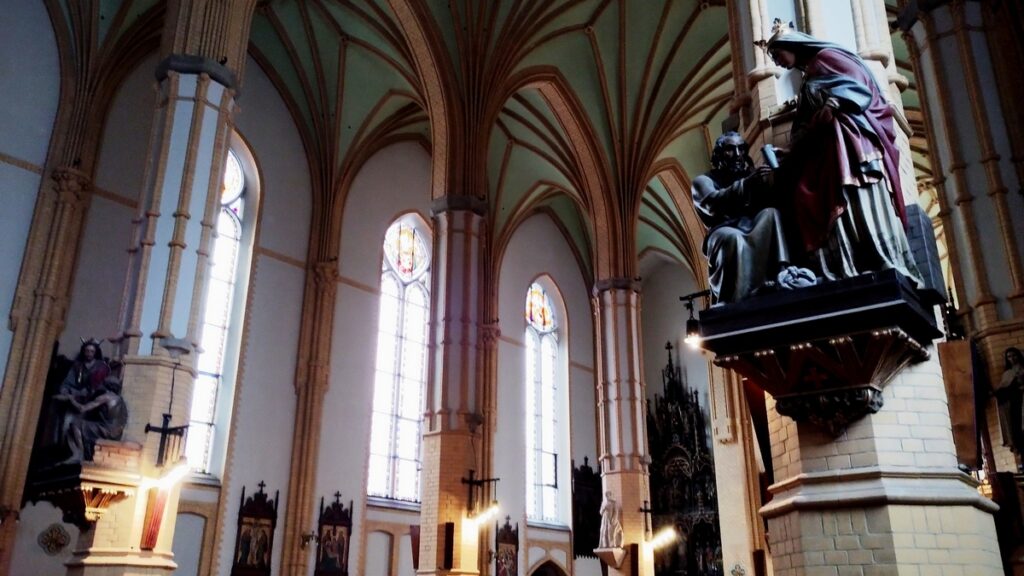 Kościół NSPJ - Filary podtrzymujące strop zdobią różne figury